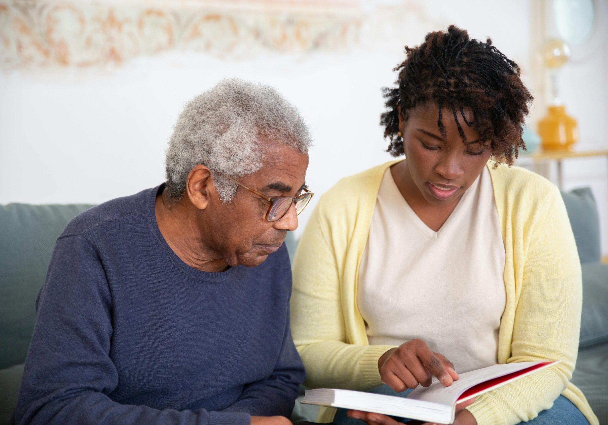 A Woman in Yellow Cardigan Talking to the Man while Reading a Book